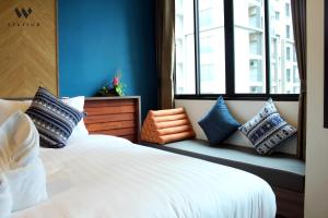 - une chambre avec un lit blanc avec des oreillers et une fenêtre dans l'établissement W Station, à Bangkok