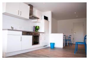 a kitchen with white cabinets and a table and chairs at CALIFORNIA Flat - EP Ticket Garantie in Rust