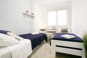 Jest to biały pokój z 2 łóżkami i biurkiem. w obiekcie Split Retreat @ Town Center w/terrace w Splicie