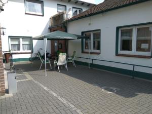埃德韋希特的住宿－Gasthof am Markt，庭院配有桌椅和遮阳伞。