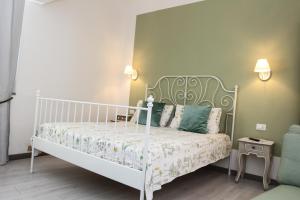 a bedroom with a white bed and a green wall at Carducci in Como