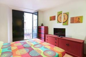 Trampantojo Apartamento en el Corazon de Pamplona في بامبلونا: غرفة نوم مع سرير ملون وخزانة