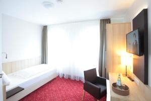 Hotel zur Schloß-Schenke في نيوفيد: غرفه فندقيه بسرير وكرسي