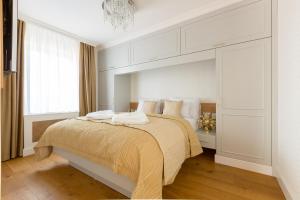 a bedroom with a large bed with white walls at Wellness Hotel Republika 24 Apartments in Plzeň