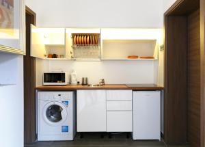 eine Küche mit einer Waschmaschine und einer Mikrowelle in der Unterkunft House Octogon in Budapest