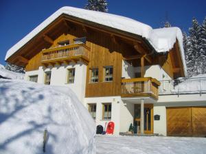 a house covered in snow in front of it at Haus Margreitter in Wald am Arlberg