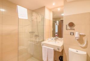a bathroom with a shower and a sink and a toilet at Hotel LIVVO Corralejo Beach in Corralejo