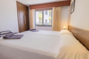 a bedroom with a large white bed with a window at Hotel LIVVO Corralejo Beach in Corralejo
