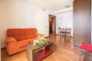 a living room with an orange couch and a table at Hotel LIVVO Corralejo Beach in Corralejo
