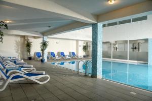 a pool in a hotel with lounge chairs and a swimming pool at Hotel Park in Lovran