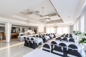 a banquet hall with white tables and black chairs at Hotel Junior in Krakow