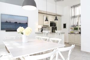 a white dining room with a white table and white chairs at Carducci in Como