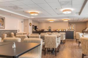 a restaurant with tables and chairs in a room at Quality Inn Sept-Iles in Sept-Îles