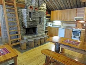 レヴィにあるPolar Star Polar Keloの石造りの暖炉と木製テーブル付きのキッチン