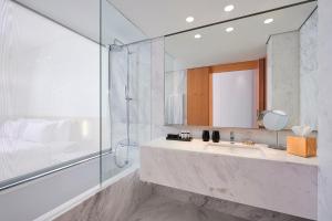 a bathroom with a sink and a shower and a mirror at Melia Palma Bay in Palma de Mallorca