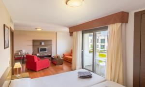 a living room with a red chair and a living room at Hotel LIVVO Corralejo Beach in Corralejo