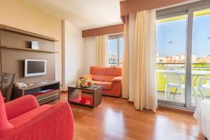 a living room with a couch and a tv at Hotel LIVVO Corralejo Beach in Corralejo