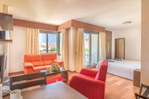 a hotel room with a bed and a living room at Hotel LIVVO Corralejo Beach in Corralejo