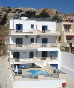 a large white building with a swimming pool at Yiorgos Studios in Palaiochora