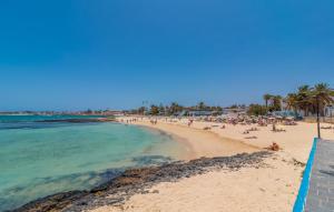 a beach with a lot of people and the ocean at Hotel LIVVO Corralejo Beach in Corralejo