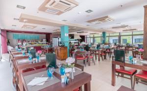 a restaurant with wooden tables and red chairs at Hotel LIVVO Corralejo Beach in Corralejo