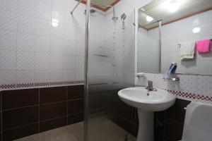 a bathroom with a glass shower and a sink at Paradaise Motel in Gangneung