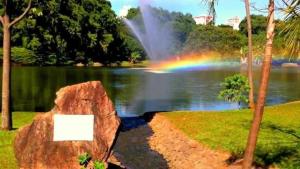 a rainbow in the middle of a lake with a rock at Apart-Hotel in Goiânia