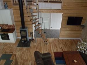 a living room with a spiral staircase and a fireplace at Rensbo Stugor in Hedemora