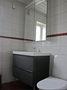 a bathroom with a sink and a toilet and a mirror at Rensbo Stugor in Hedemora