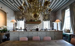 a large dining room with a large chandelier at Château du Tertre in Arsac