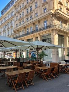 a group of tables with umbrellas in front of a building at Imperium Residence - Experience the most Luxurious Apartment in Vienna Center in Vienna