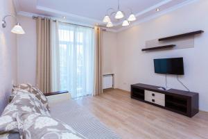 a living room with a couch and a television at Apartments Roomer 2 in Minsk