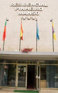 Un bâtiment avec des drapeaux à l'avant dans l'établissement Hotel Pinheiro Manso, à Seara