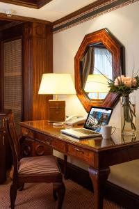 a desk with a laptop and a lamp and a mirror at Hotel Plaza San Francisco in Santiago