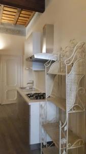 トリノにあるSavoia Aptの白いキャビネット、シンク、棚付きのキッチン