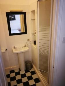 a bathroom with a sink and a shower and a mirror at Delamere Hotel in Blackpool