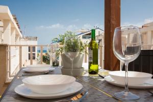una mesa con platos y copas de vino en el balcón en SingularStays Puzol Beach VI, en Puzol