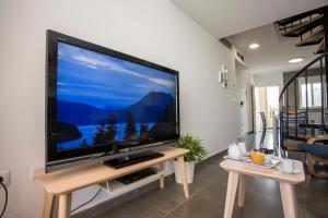TV de pantalla plana grande en un soporte de madera en la sala de estar. en SingularStays Puzol Beach VI, en Puzol