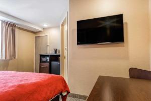 a hotel room with a bed and a flat screen tv at Rodeway Inn Chicago/Evanston in Lincolnwood