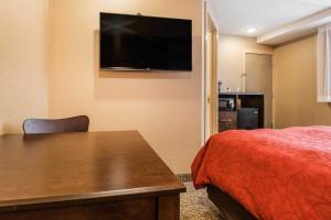 Habitación de hotel con cama y TV de pantalla plana. en Rodeway Inn Chicago/Evanston, en Lincolnwood