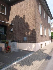 a brick building with a shadow on the side of it at Hotel Societät in Emmerich