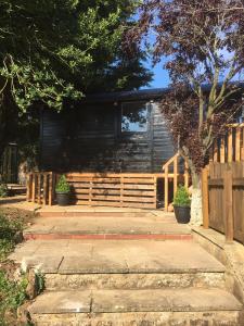 a house with a wooden fence and a porch at The Cherry Tree Gypsy Wagon in Banbury