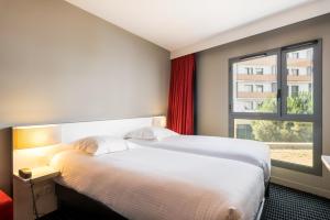 Habitación de hotel con cama y ventana en Résidence Ôtelia Affaires & Bien-être, en Lyon
