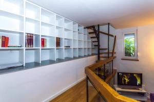 a living room with bookshelves and a spiral staircase at Shiny apartment near beaches and center in Split