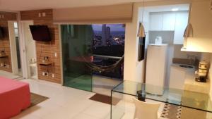 a room with a glass table and a view of a city at Apart-Hotel in Goiânia