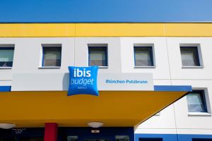 - un bâtiment avec un panneau d'autobus dans l'établissement ibis budget Muenchen Putzbrunn, à Putzbrunn