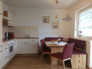 a kitchen with a table and chairs and a kitchen with a sink at Krinzerhäusl in Seefeld in Tirol