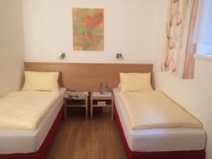 two beds in a small room with a table at Krinzerhäusl in Seefeld in Tirol