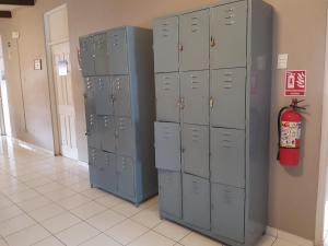 a row of lockers in a room with a fire extinguisher at Managua Backpackers Inn in Managua
