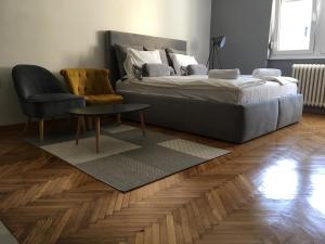 a bedroom with a bed and a chair and a table at Apartment Silver in Belgrade